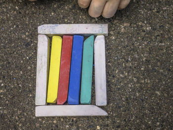 Close-up of person hand by multi colored chalks