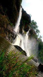 Low angle view of waterfall against sky