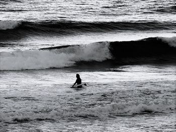 Silhouette of man with surfboard on beach