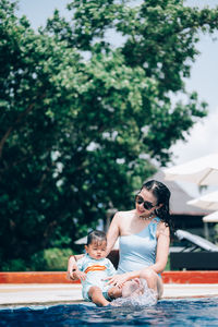 Rear view of mother and daughter on swimming pool