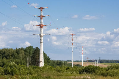 Low angle view of electricity pylon on field against sky