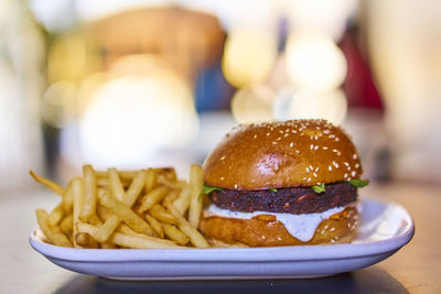 Close-up of burger and french fries in plate on table