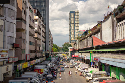 Vehicles on road amidst buildings in city