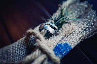 Close-up of wedding rings with rosemary on burlap