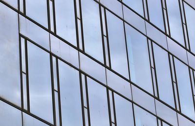 Low angle view of glass building against sky