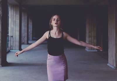 Young woman standing against wall