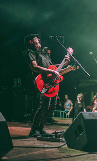 People playing guitar at music concert