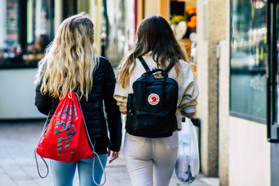 Rear view of women walking on street in city