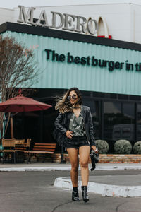 Full length of woman standing against wall