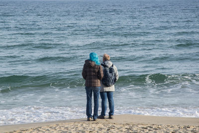 Rear view of couple standing on beach