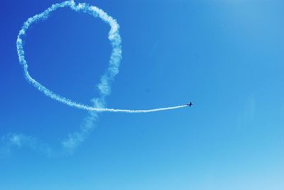 Low angle view of airplane flying against blue sky