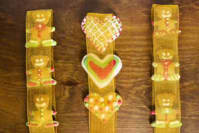 Gingerbread cookies wrapped in yellow ribbon on wooden table