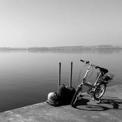 High angle view senior man with bicycle sleeping on pier against sky