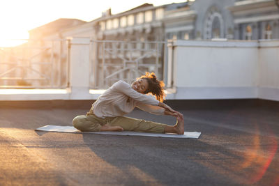 Full length of teenager girl exercising on terrace