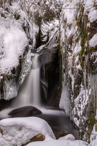 Scenic view of waterfall in forest during winter