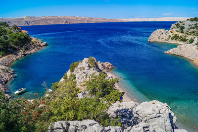 High angle view of rocks on sea shore against sky