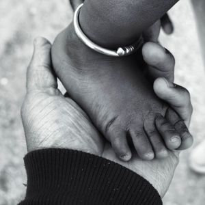 Cropped hand of man holding baby foot