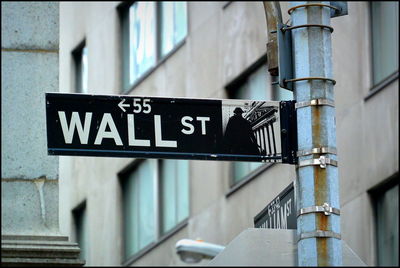 Close-up of road sign against building