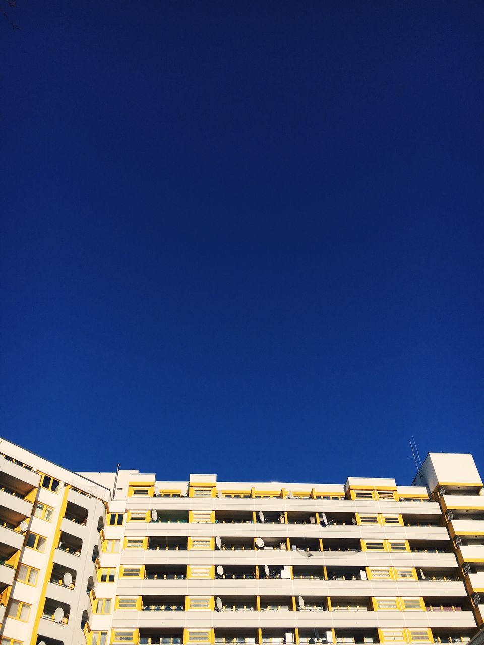 LOW ANGLE VIEW OF RESIDENTIAL BUILDINGS AGAINST BLUE SKY