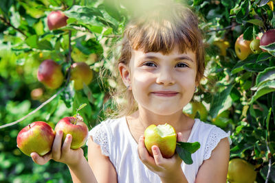 Portrait of young woman holding fruit