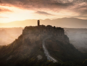 View of castle on mountain against cloudy sky