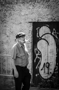 Full length of young man standing against wall