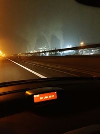 Light trails on road against sky at night