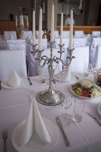 High angle view of candlestick holder on table with place setting