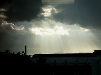 Silhouette of buildings against cloudy sky