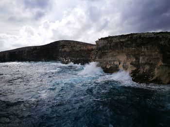 Rocks in sea against sky