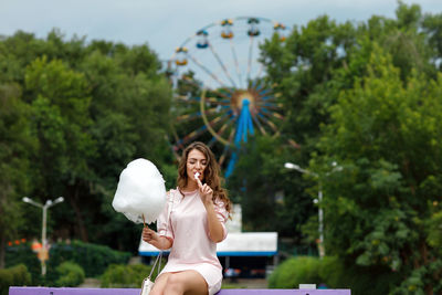 Smiling young woman holding cotton candy