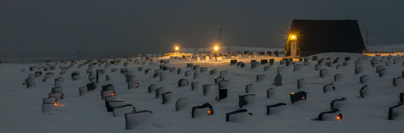Panoramic view of illuminated street lights on beach against sky at night