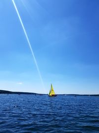 Sailboat in sea against blue sky