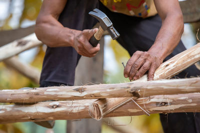 Midsection of man working on wood