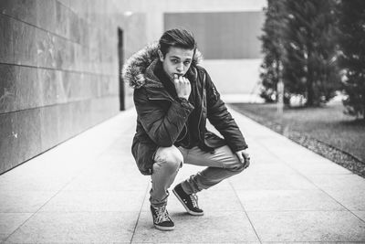 Young man standing on footpath