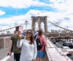 Smiling mid adult woman taking selfie on brooklyn bridge