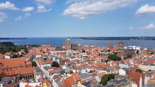 High angle view of townscape by sea against sky