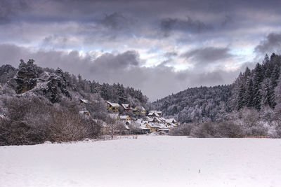 Scenic view of a village in a winterly valley in the woodland