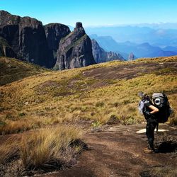 Woman standing on mountain against sky