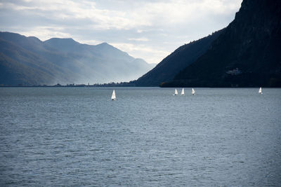 Scenic view of sea and mountains against sky