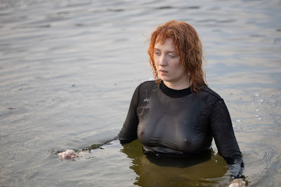 Portrait of young woman standing in sea