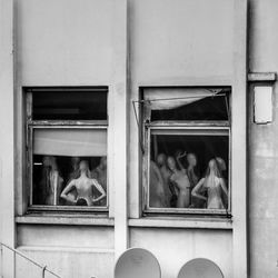 Mannequins in building seen through windows