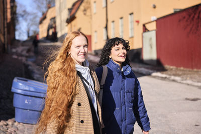 Female friends walking together ourdoors on walkway in city