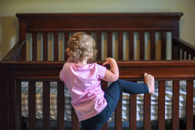 Rear view of girl climbing on railing