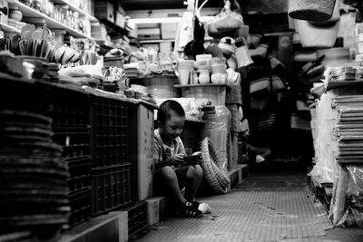 Full length of woman sitting in market