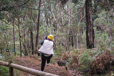 Rear view of man walking in forest