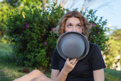 Portrait of a young woman holding plant