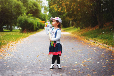 Full length of girl standing on road