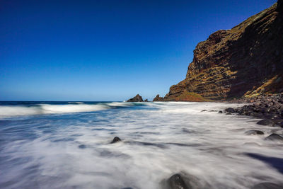 Scenic view of sea against clear blue sky