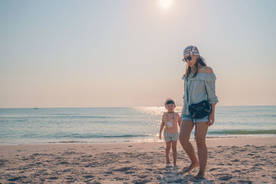 Full length of girl on beach against sky